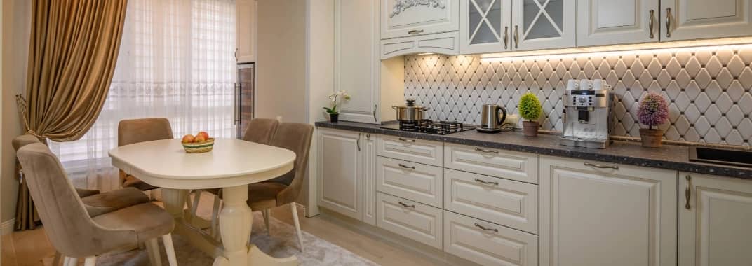 Beautiful beige kitchen with a dining table and state-of-the-art appliances