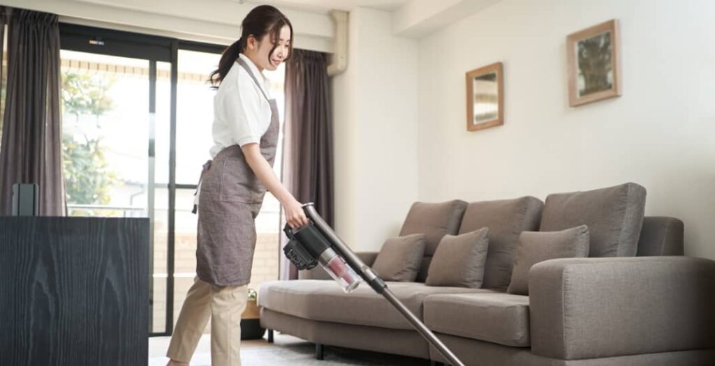 Asian woman vacuuming in the living room