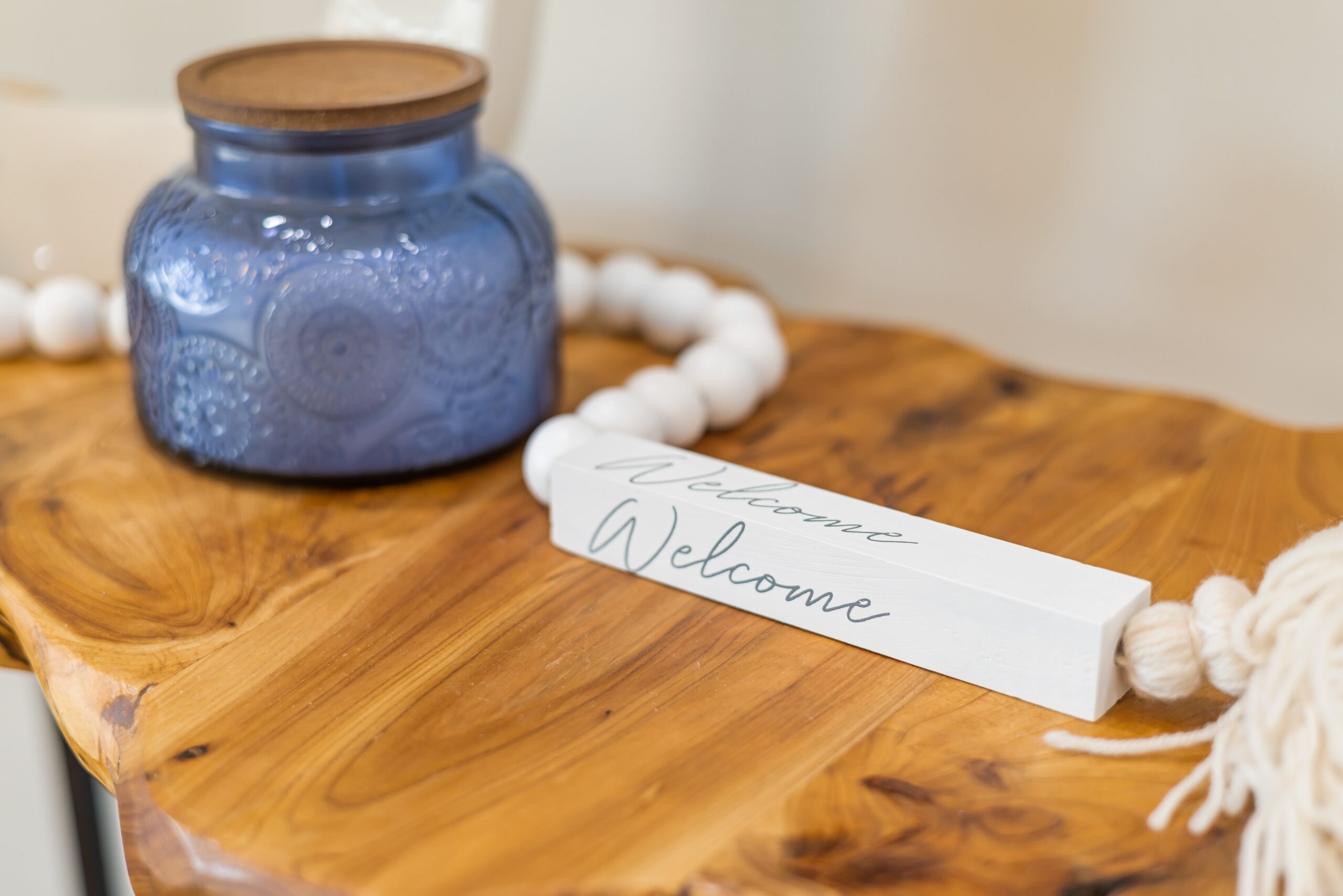 blue jar and welcome sign on a wooden table