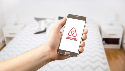 person holding a phone with AirBnb logo on screen